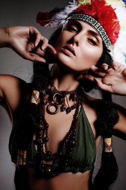 Hint tarzı gri arka plan üzerinde parlak tüylü şapkalı güzel kız modeli