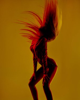 Güzel, seksi, sarışın kız, neon ışıkta dans ediyor.           