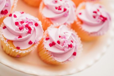 Pembe krema ve kalp sprinkles ile cupcakes