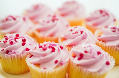 Pembe krema ve kalp sprinkles ile cupcakes