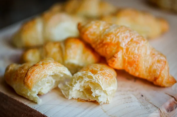 Färsk croissant på trä bakgrund — Stockfoto