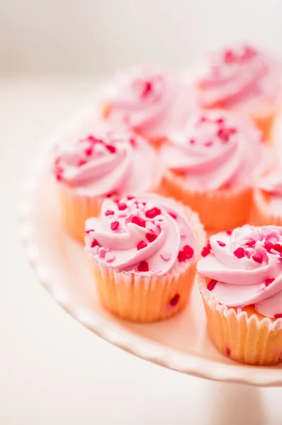 Cupcakes con crema rosa y chispas de corazón — Foto de Stock