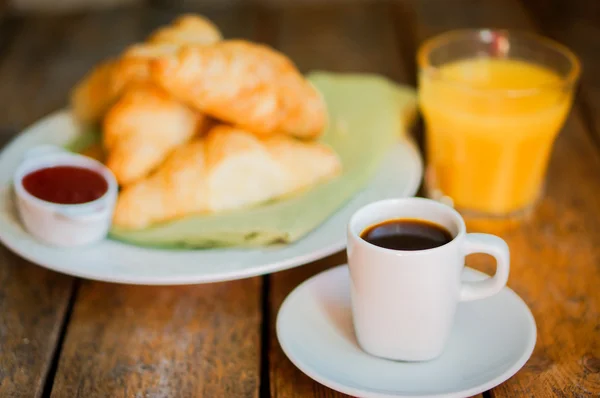 Sabroso desayuno: café con croissants, zumo de naranja y mermelada en w —  Fotos de Stock