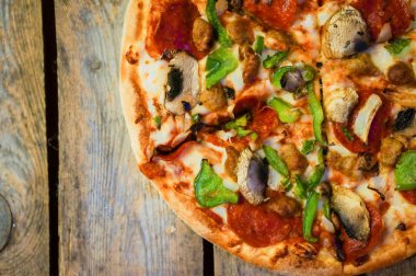 ev yapımı biberli pizza rustik ahşap zemin üzerine dilimlenmiş