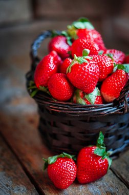 Ahşap arka plan üzerinde taze çilek sepeti