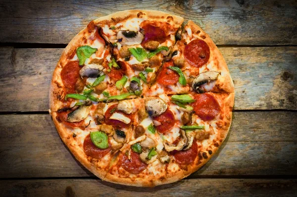 ev yapımı biberli pizza rustik ahşap zemin üzerine dilimlenmiş