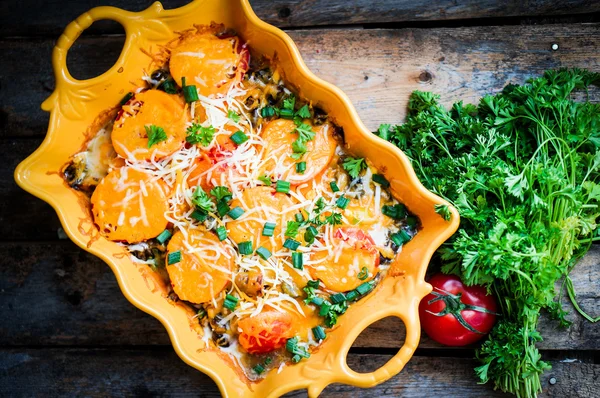 Horneado verduras en un plato sobre fondo de madera —  Fotos de Stock