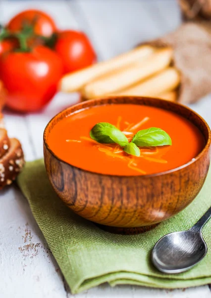 Tomatoe soep met brood stokken en basilicum op houten achtergrond — Stockfoto