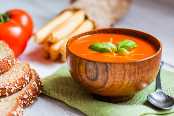 Tomatensuppe mit Stockbrot und Basilikum auf Holzgrund — Stockfoto