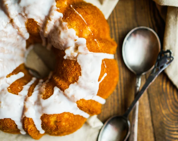 Bundt tårta med vit glasyr på rustika bakgrund — Stockfoto