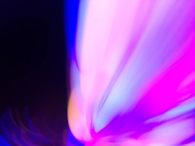 Parlayan neon renkleri yumuşak bulanık hareketle pürüzsüz eğimlerde akar. Soyut renkli ışık hareketi.