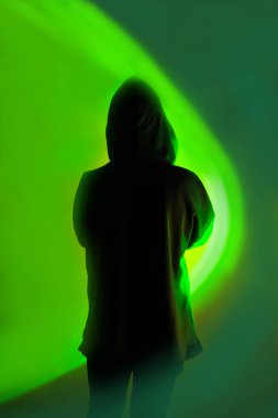 Akıllı telefondaki kişisel bilgilerin güvenli bir şekilde depolanması. Karanlık kapüşonlu bir figür ve canlı neon arka planda telefonu var..