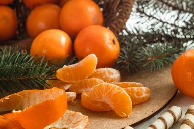 Noel konsepti portakal kokulu mandallar ve ahşap bir arka planda çam dalları.