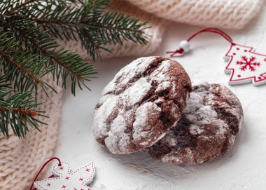 Noel ağacının dallarına yakın bir arka planda çikolatalı, kırışık kurabiyeler. Çikolatalı kek. Geleneksel Amerikan kurabiyeleri.