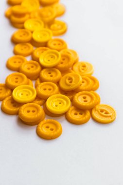 Beyaz arkaplanda çok farklı sarı düğmeler.