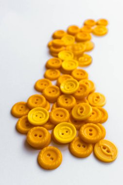 Beyaz arkaplanda çok farklı sarı düğmeler.