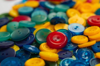 Düğme arkaplanı. Bulanık arkaplandaki kıyafetler için bir sürü parlak plastik düğme.