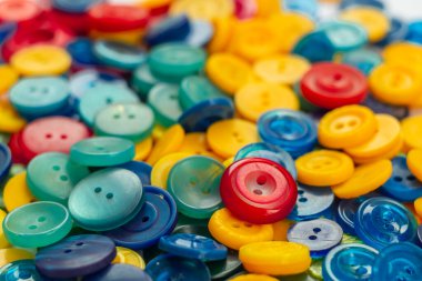 Düğme arkaplanı. Bulanık arkaplandaki kıyafetler için bir sürü parlak düğme.