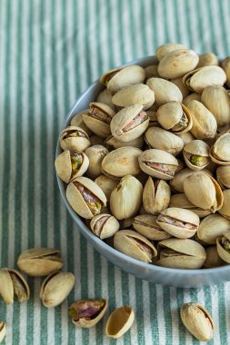 Şam fıstığını seramik bir kaseye koy, kırsal dokuya ve gün ışığına uygun en az besin tasarımı yap..