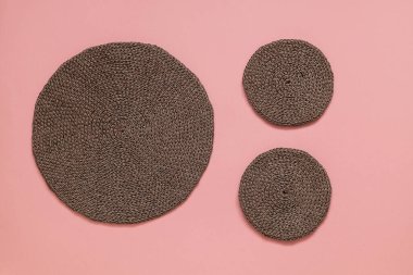 Pembe arka planda gösterilen yuvarlak örgü altlıkları, el işçiliğini, rahat ev atmosferini, ekolojik bilinçli yaşam tarzını ve modern doğal dekoru temsil ediyor..