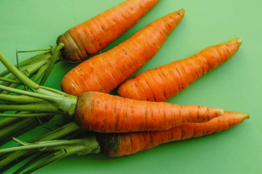 Yeşil arka planda taze olgun turuncu havuçlar..