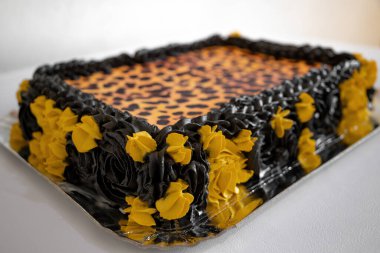 Leopar desenli, siyah ve sarı detaylarla süslenmiş yaratıcı tatlı pasta.