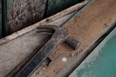 Kirli ahşap yüzeyin altında seçici odaklı kırsal bir binada metal çekiç.