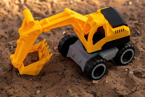 黄色和黑色玩具挖掘机在地面上的缩影 有选择的焦点 — 图库照片