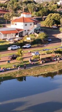 Lagoa Santa, Goias, Brezilya - 05 05 2024. Balıkçıların belediye gölü etrafında konuşlandığı göl yolu boyunca dikey dron dönüyor..