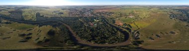 Lagoa Santa, Goias, Brezilya - 07 05 2024. Geniş panoramik dron görüntüsü, Lagoa Santa kasabası, terma lagünü ve Apore nehrinin kırsal araziyi geçtiğini gösteriyor..