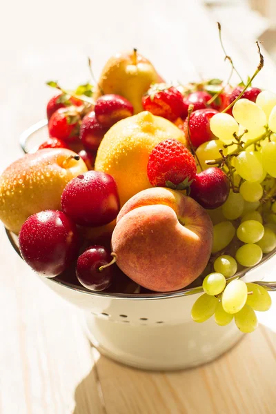 Frische gemischte Früchte, Beeren im Sieb. Liebe Früchte, Beeren. Sonnenlicht — Stockfoto