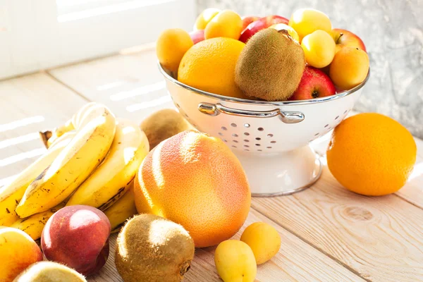 Frische gemischte Früchte in Schale auf hellem Untergrund — Stockfoto