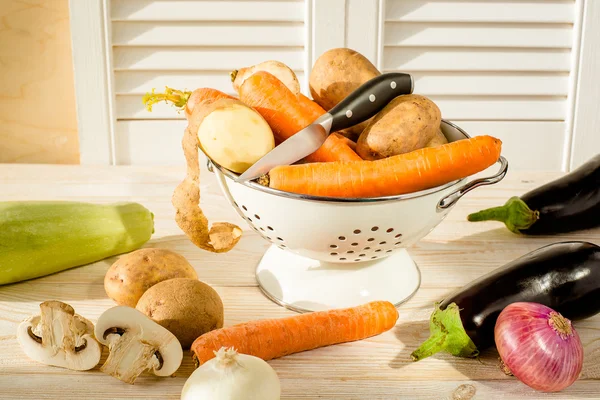 Mixed village vegetables in colander on wooden background — Stock Photo, Image