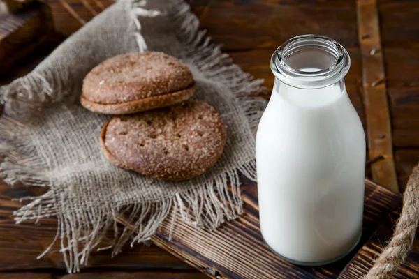 Natuurlijke volle melk in fles en op oude houten achtergrond — Stockfoto