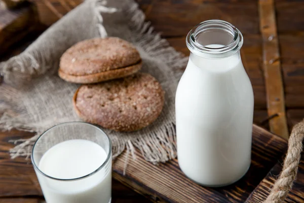 Přirozené plnotučné mléko v lahvi a na staré dřevěné pozadí — Stock fotografie
