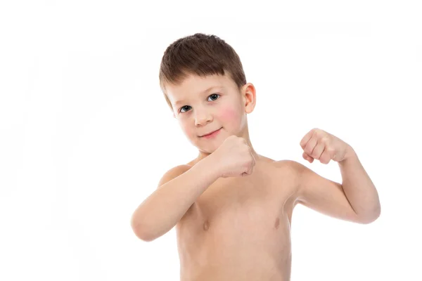 Liten pojke försöker visa sin biceps muskler Stockfoto