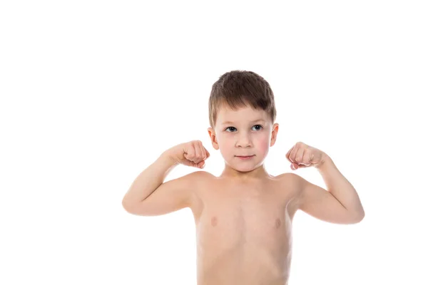Liten pojke visar sina biceps muskler Stockbild