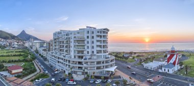 Cape Town günbatımı okyanus ve yol sağdaki tarafından geçen araçları ile