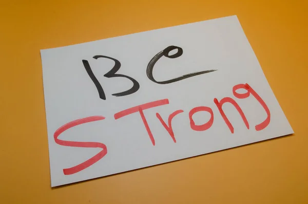 Beyaz kart üzerinde 'Be STRONG' mesajı ilham verici, zorlu zamanlar için güçlü motivasyon ve dayanıklılık sunuyor.