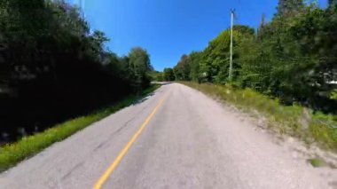 İleri görüşlü kır yolu ön plaka, verimli ağaçlardan oluşan yüksek kenar duvarlar. Manitoulin Adası 'nda sonbaharın başında kır yolunda araba kullanmak. Manitou Gölü yakınlarındaki Gibraltar Yolu, Ontario, Kanada.