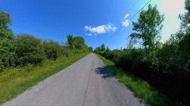 İleri görüşlü kır yolu ön plaka, verimli ağaçlardan oluşan yüksek kenar duvarlar. Manitoulin Adası 'nda sonbaharın başında kır yolunda araba kullanmak. Manitou Gölü yakınlarındaki Gibraltar Yolu, Ontario, Kanada.