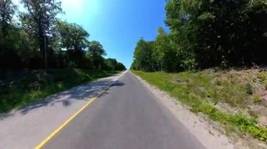 İleri görüşlü kır yolu ön plaka, verimli ağaçlardan oluşan yüksek kenar duvarlar. Manitoulin Adası 'nda sonbaharın başında kır yolunda araba kullanmak. Manitou Gölü yakınlarındaki Gibraltar Yolu, Ontario, Kanada.