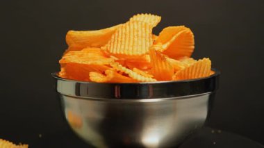 Çıtır altın patates cipsi yavaş çekimde düşüyor. Fast food ve abur cubur. Yüksek kalorili sağlıksız yiyecekler, sağlıksız yağlar, tuz ve kimyasal yan ürünler. Ekstra işlenmiş atıştırmalık. Yüksek sağlık riskleri