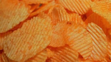 Çıtır altın patates cipsi yavaş çekimde düşüyor. Fast food ve abur cubur. Yüksek kalorili sağlıksız yiyecekler, sağlıksız yağlar, tuz ve kimyasal yan ürünler. Ekstra işlenmiş atıştırmalık. Yüksek sağlık riskleri