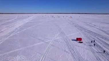 Donmuş Simcoe Gölü 'nün uçan görüntüsü kardaki kar araçları ve buz balıkçılığı kulübelerini gösteriyor. Buz balıkçılığı kulübeleri ya da manzaralı havadan çekilen kulübeler. Buz balıkçıları için kiralık barınaklar.