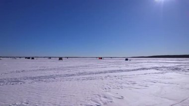 Donmuş Simcoe Gölü 'nün uçan görüntüsü kardaki kar araçları ve buz balıkçılığı kulübelerini gösteriyor. Buz balıkçılığı kulübeleri ya da manzaralı havadan çekilen kulübeler. Buz balıkçıları için kiralık barınaklar.