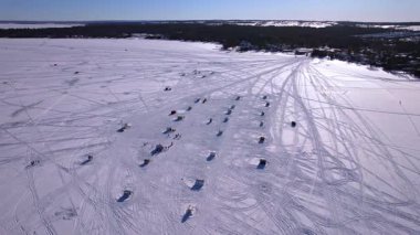 Donmuş ILake Simcoe 'da kar aracı kayak izleri ve balıkçı kulübeleri. Cooks Bay, Innisfil, Ontario Canada kış yolculuğu macera konsepti ve buzda balık avlama sezonunda aile eğlencesi. Balıkçılık tekneleri.