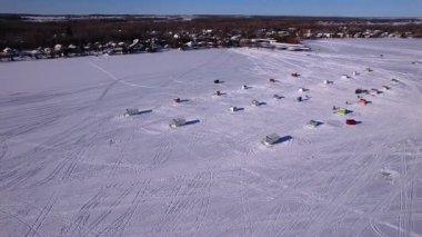 Donmuş Simcoe Gölü 'ndeki kar aracı kayak izleri ve balıkçı kulübeleri. Cooks Bay, Innisfil, Ontario Canada kış yolculuğu macera konsepti ve buzda balık avlama sezonunda aile eğlencesi. Balıkçılık tekneleri.