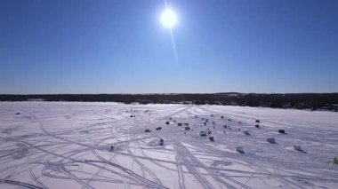 Donmuş Simcoe Gölü 'ndeki kar aracı kayak izleri ve balıkçı kulübeleri. Cooks Bay, Innisfil, Ontario Canada kış yolculuğu macera konsepti ve buzda balık avlama sezonunda aile eğlencesi. Balıkçılık tekneleri.