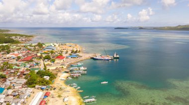Filipinler 'in Dapa şehrindeki deniz limanı. Balıkçı köyü ve gemiler, yukarıdan bakın. Güneşli havalarda deniz manzarası.